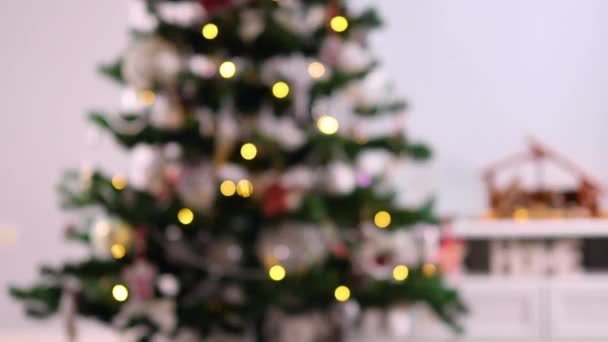 Verschwommener Weihnachtsbaum mit Lichtern zu Hause. Weihnachten feiern mit Dekoration und stimmungsvoller Beleuchtung. 4k - Filmmaterial, Video
