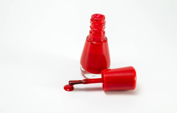 Червоний лак для нігтів, скляна пляшка на білому тлі
. - Фото, зображення