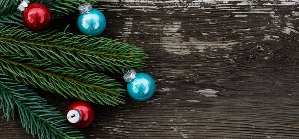 Fondo navideño con ramas de abeto y bolas sobre mesa de madera.  - Foto, Imagen