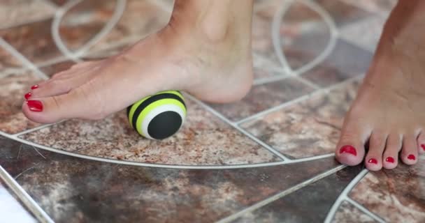 Fußmassagegerät und Trigger-Massageball. Frau massiert ihren Fuß auf Ball - Filmmaterial, Video
