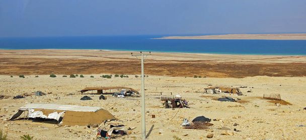 Cabañas de pueblo de un campamento nómada en el desierto cerca del mar en el Medio Oriente en verano sin gente - Foto, imagen