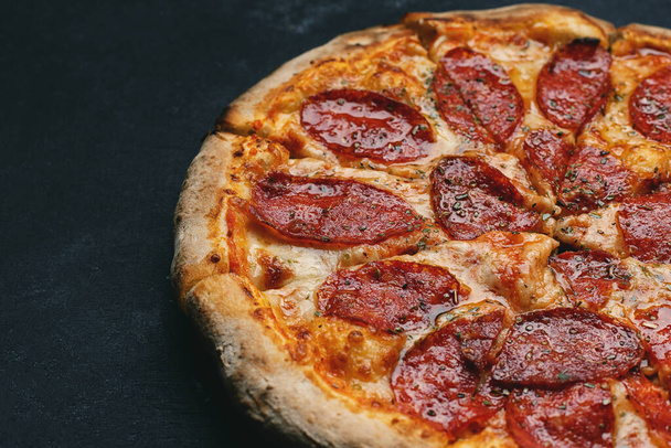Crispy pizza with sausage and spices on gray concrete - Zdjęcie, obraz