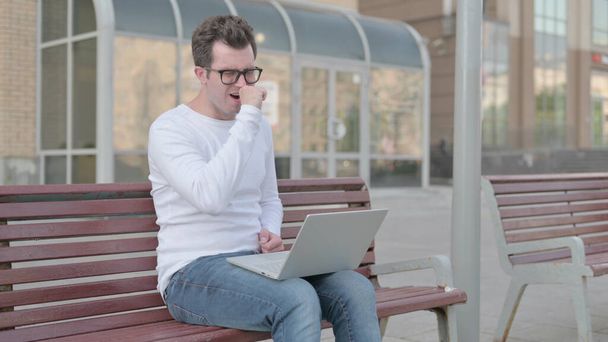 Coughing Casual Man Using Laptop while Sitting Outdoor on Bench - Foto, Imagem