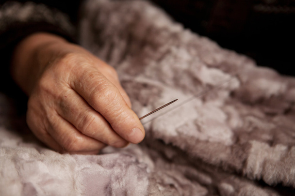Руки літньої жінки для шиття
 - Фото, зображення