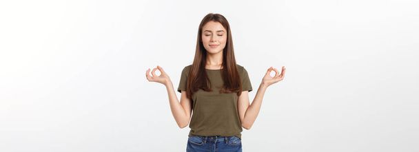 Beautiful young woman in yoga position and meditating isolated over gray background. - Foto, afbeelding