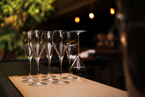 καθαρίστε άδεια ποτήρια κρασιού στον πάγκο μπαρ στο κοντινό εστιατόριο - Φωτογραφία, εικόνα