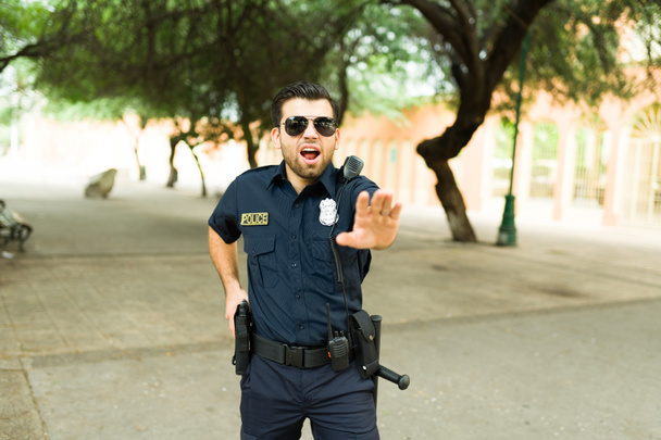 怒りの警察官が容疑者に叫んで銃を突きつけ  - 写真・画像