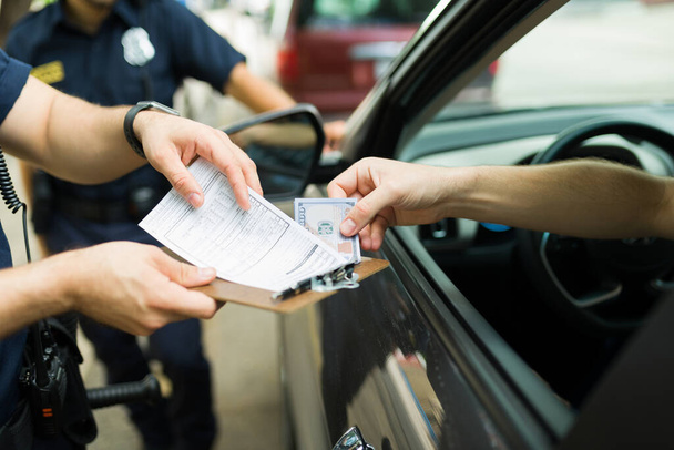Водій дає хабарі поліцейським поліцейським за отримання штрафу або швидкісного квитка
  - Фото, зображення