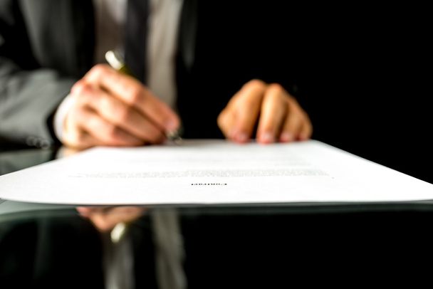 Empresário assina documento com foco no texto Contrato
 - Foto, Imagem