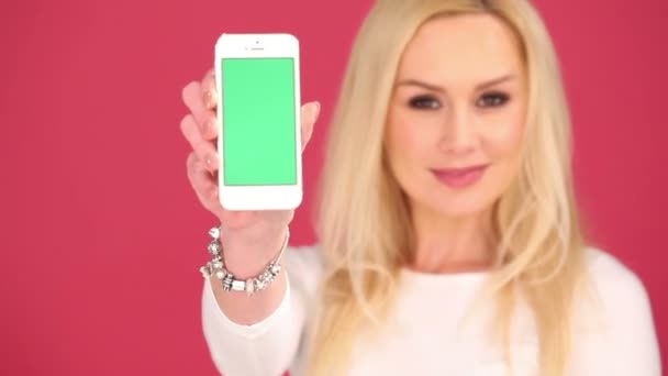Mulher atraente exibindo um telefone celular em branco
 - Filmagem, Vídeo