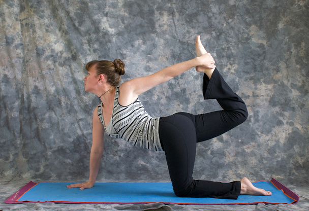 Donna che fa Yoga postura Vyaghrasana La Tigre Posa variazione
 - Foto, immagini