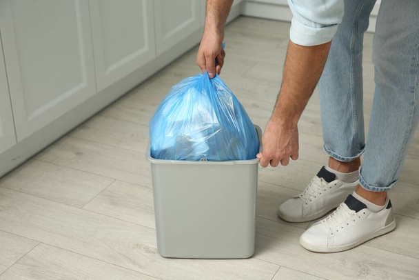 Man taking garbage bag out of bin at home, closeup - Fotó, kép