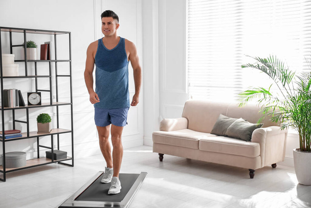 Sporty man training on walking treadmill at home - Photo, Image