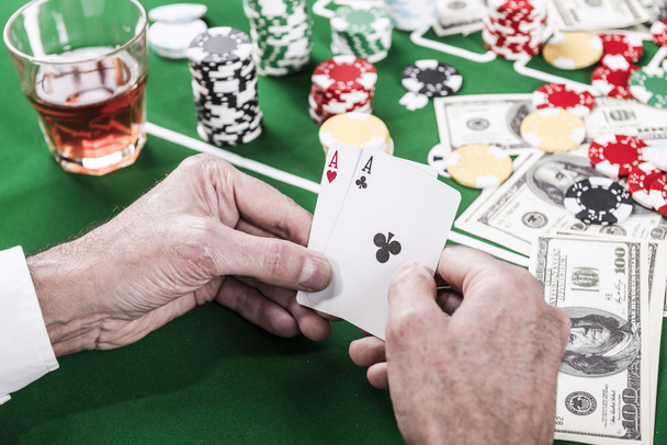Man holding cards while sitting at the poker table - Valokuva, kuva