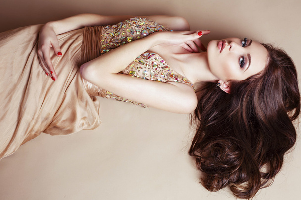 beautiful girl with luxurious dark hair in sequin dress posing at studio  - Fotoğraf, Görsel