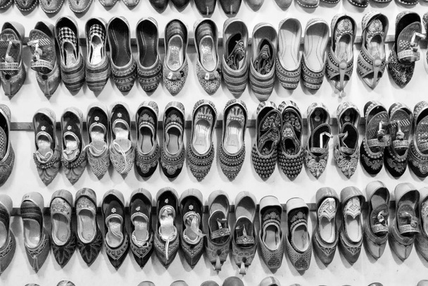 Para pięknych damskich butów Rajasthani na sprzedaż. Jaisalmer, Rajasthan, Indie. - Zdjęcie, obraz