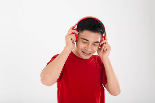 Asian guy in red enjoy music - Фото, изображение