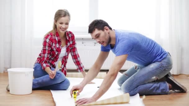 smiling couple measuring wallpaper - Footage, Video