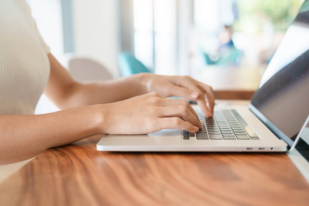 kobieta korzystająca z laptopa, niezależna kobieta wpisująca notatnik komputerowy klawiatury w kawiarni lub nowoczesnym biurze. technologia, cyfrowa koncepcja sieciowa i internetowa - Zdjęcie, obraz