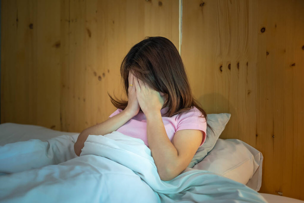 mujer que tiene migraña dolores de cabeza durante la cama en casa. insomnio, insomnio, cansancio, sufrimiento y conceptos estresados - Foto, Imagen