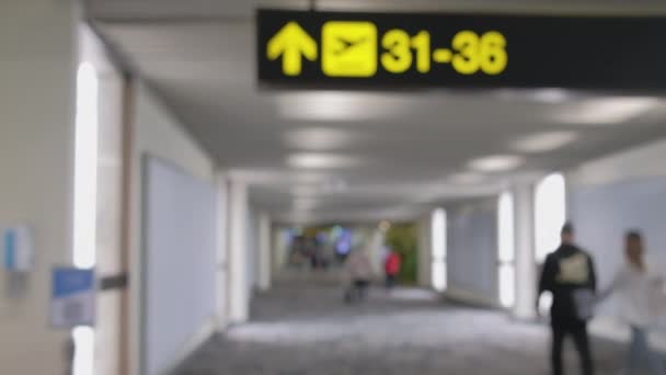 Brede wazige beelden. Mensen lopen op voetgangers loopbrug, haasten zich bij boarding gate op Don Mueang International Airport terminal, Reis naar bestemmingen met bagage bij vertrek hal. - Video