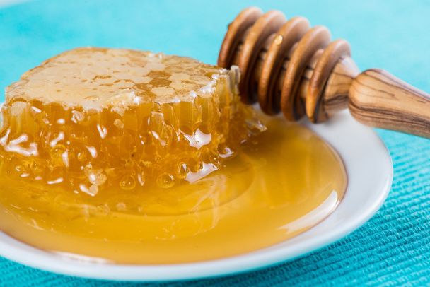 cloese view on fresh honey and wooden dipper - Foto, afbeelding