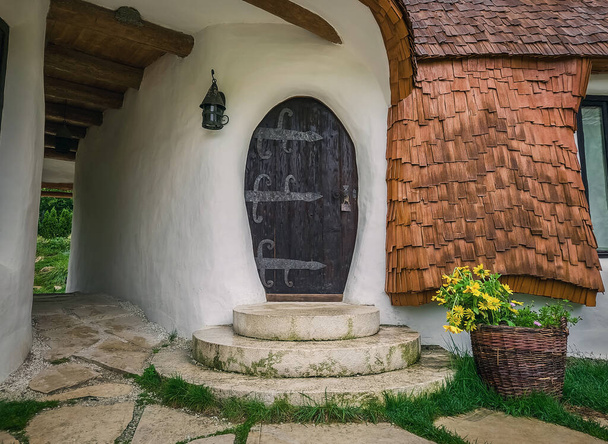 Zamek Clay z Doliny Wróżki, kompleks turystyczny w Transylwanii, Rumunia. Widok z bliska na malutkie drzwi wejściowe, dom hobbitów fantasy z opowieści - Zdjęcie, obraz