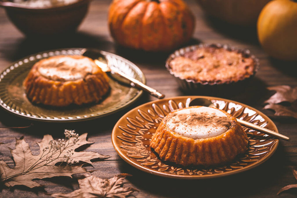 カボチャのミニパイ、古い木製の背景に感謝祭の日のために作られたタルト。健康的な秋の食のコンセプト - 写真・画像