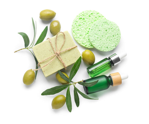 Beyaz arka planda gerekli yağ, sabun, makyaj süngeri ve yeşil zeytin şişeleri - Fotoğraf, Görsel