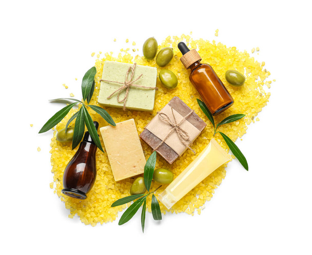Composition avec bouteilles d'huile essentielle d'olive, savonnettes et sel de mer sur fond blanc - Photo, image