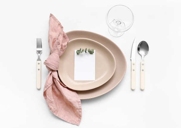 白い背景に空白のカードとユーカリの枝と美しいテーブルの設定 - 写真・画像