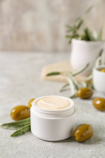 Банка натурального оливкового крема на светлом столе - Фото, изображение