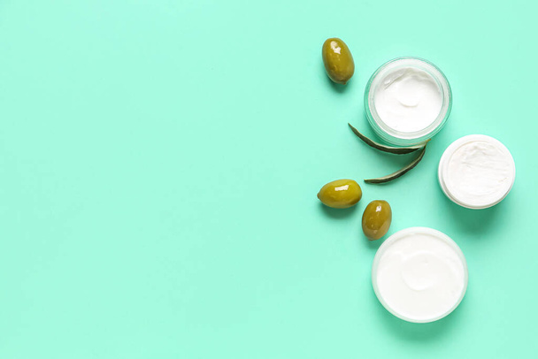Jars of natural olive cream on color background - Φωτογραφία, εικόνα