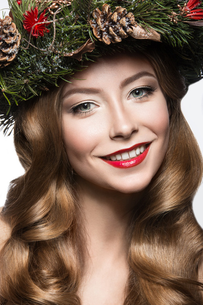 Beautiful girl with a wreath of fir branches and cones. New Year image. Beauty face. - Foto, Bild