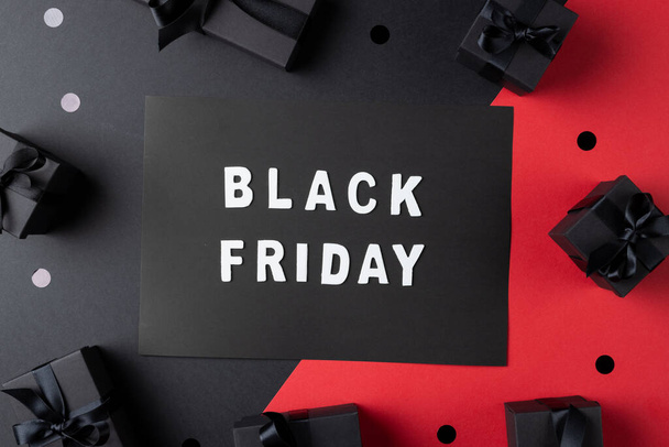 Composition of presents and black friday text on gray and pink background. Retail, shopping and black friday concept. - Fotoğraf, Görsel