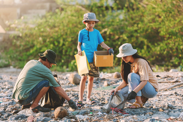 Az ázsiai családi környezet megőrzése önkéntesekből álló csapatmunka segít a műanyag és hab szemét szedésében a park területén.Önkéntes világnap. - Fotó, kép