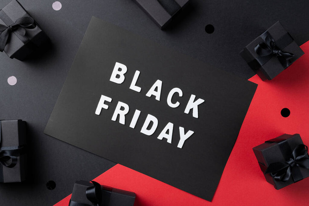 Composition of presents and black friday text on gray and pink background. Retail, shopping and black friday concept. - Фото, зображення