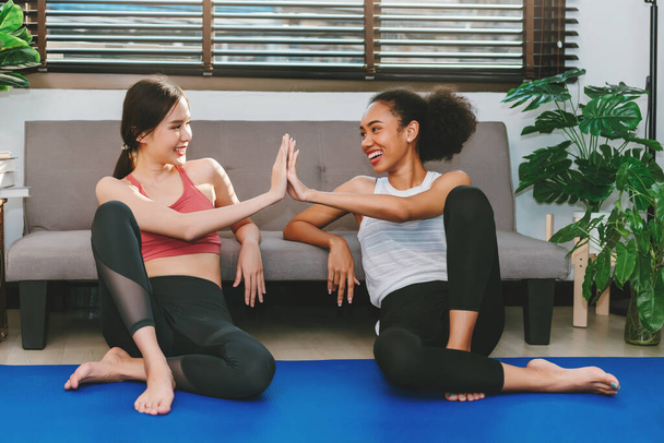 Young adult women relaxing ater doing yoga ,talking together  , exercising at home with friends , sport and recreation concept. - Foto, Imagem