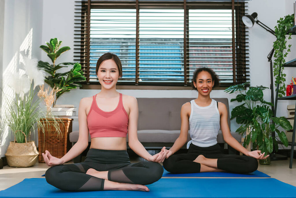 Fiatal felnőtt nők jógáznak, otthon gyakorolják a barátokkal, sport és rekreációs koncepció - Fotó, kép