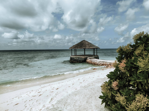 Maldives, the deserted beach with water cafe. Summer vacation on a tropical island. Luxury travel. Tranquility and relaxation. A picture in calm muted colors. - Photo, Image