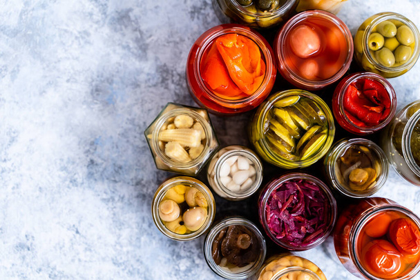 Cucumber, pepper, tomatoes, mushrooms pickling and canning into glass jars. Ingredients for vegetables preserving. Top view. Flat lay. - Photo, Image