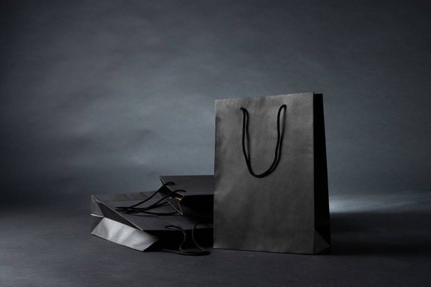 Composition of gray paper shopping bags on gray background. Retail, shopping and black friday concept. - 写真・画像