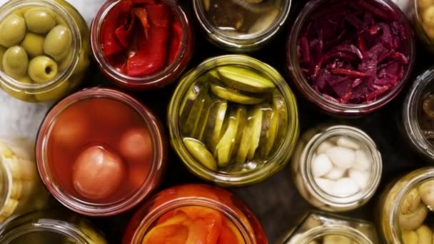 Various kinds preserves vegetables and mushrooms in glass jars. Top view, flat lay - Footage, Video