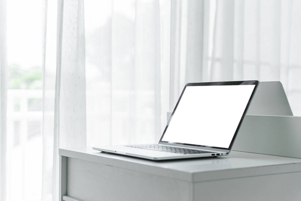 Ordenador portátil con pantalla en blanco en la mesa blanca en el interior del hogar o fondo de oficina - Foto, imagen