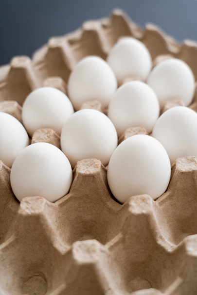 Natural chicken eggs in carton tray on blurred grey background - Photo, Image