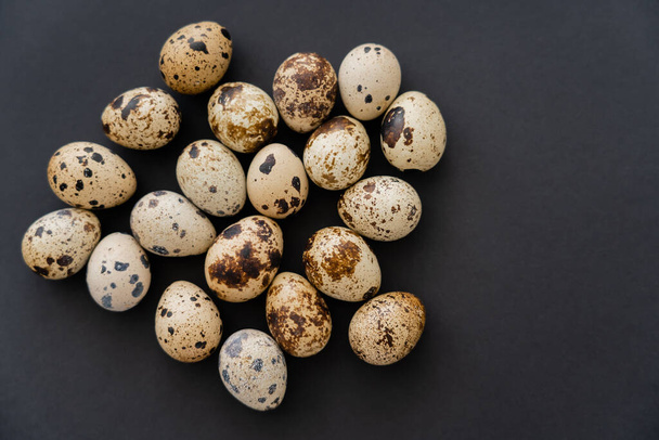 Vista dall'alto delle uova di quaglia naturali sulla superficie nera  - Foto, immagini