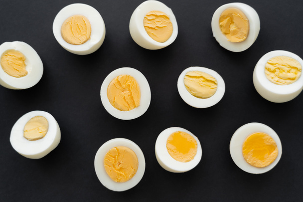 Top view of organic boiled eggs on black background  - Foto, Bild