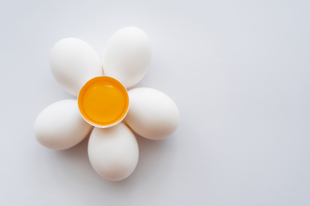 Flat lay with yolk in shell on eggs on white background  - Фото, изображение