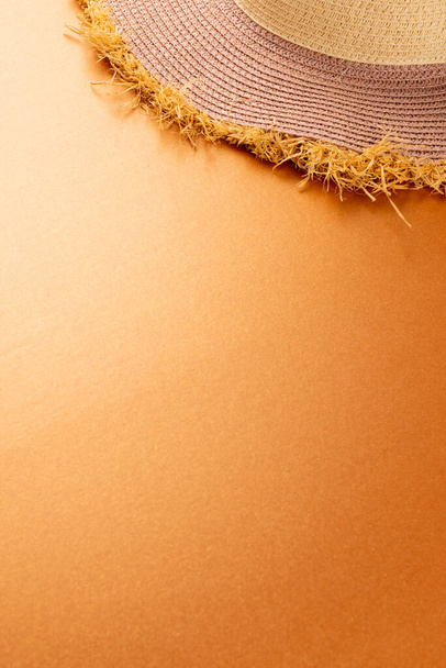 Vertical image of straw hat on yellow surface. Clothes, textiles, fashion, style and outfit concept. - Foto, Bild