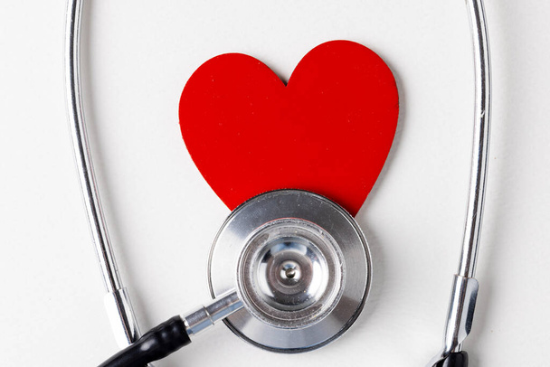 Image of red heart and stethoscope on white surface. Health, medicine, prevention and heart illnesses awareness concept. - Φωτογραφία, εικόνα